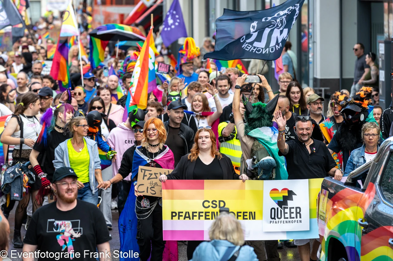 Teilnehmende der CSD-Demonstration in Pfaffenhofen mit Pride-Flaggen und Queer-Pfaffenhofen-Banner